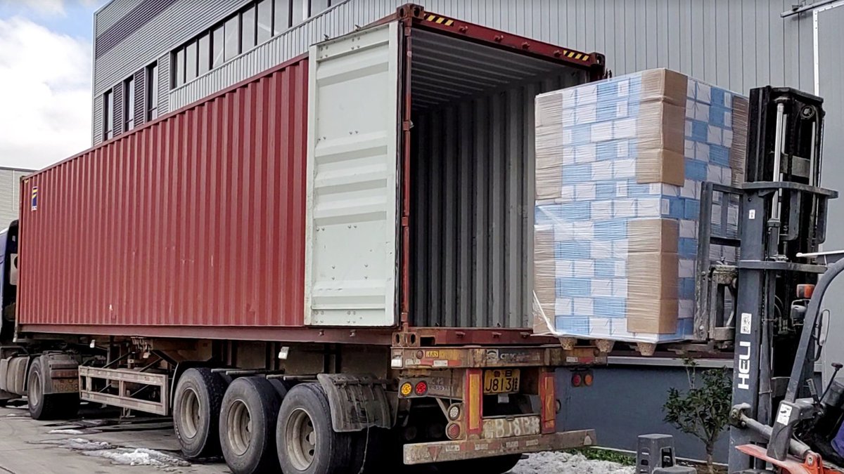 Forklift loading pallets of cat litter into shipping container at Gormeet factory